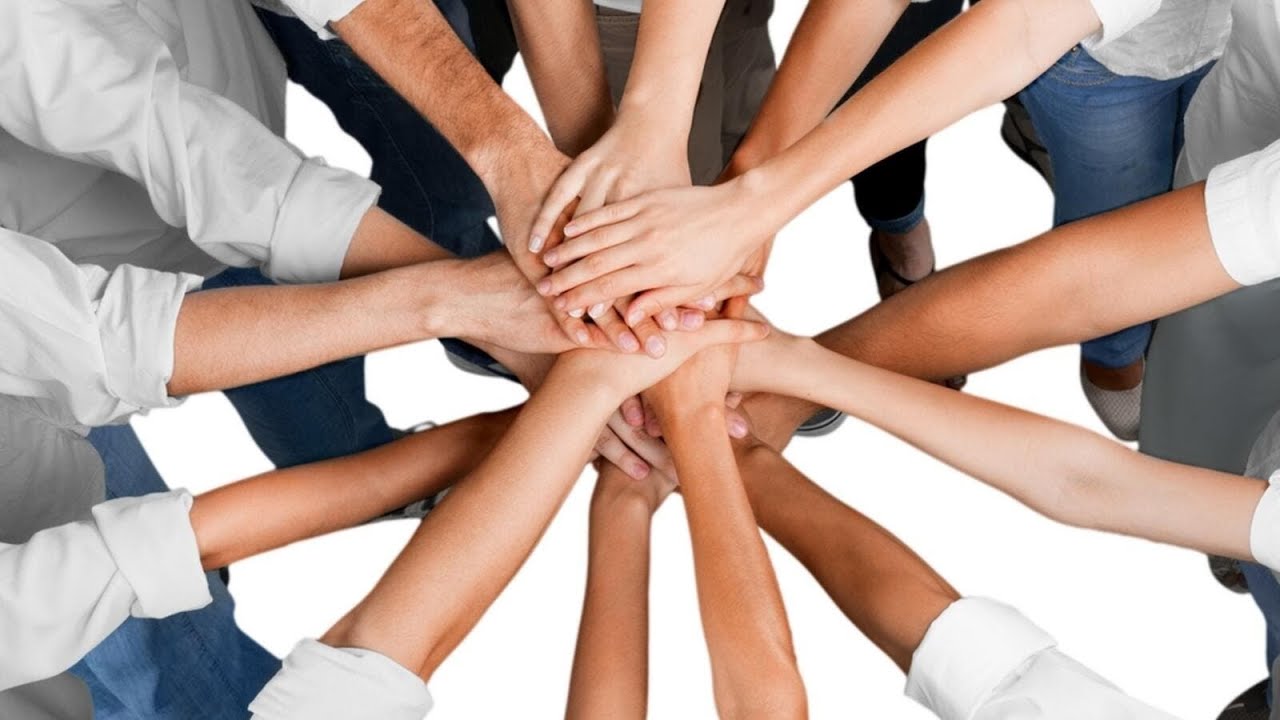 Diverse group of people joining hands in teamwork and unity
